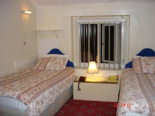 a hotel room with two beds and a window at Victoria Park Hotel in Manchester