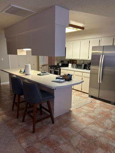 una cocina con una isla grande con sillas y nevera en Rare four Bedroom MeadviewVacation Home - Grand Canyon West-Skywalk, en Meadview