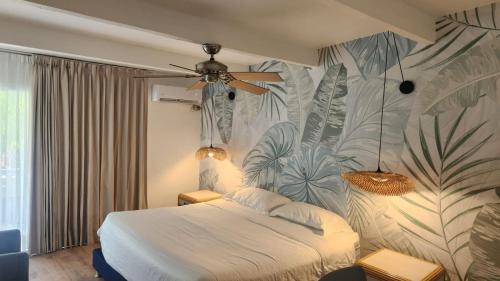 1 dormitorio con 1 cama con papel pintado tropical en Hotel Cocoplum Beach en San Andrés
