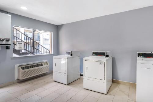 a laundry room with two washers and an air conditioner at Econo Lodge Inn & Suites Virginia Beach - Norfolk in Virginia Beach