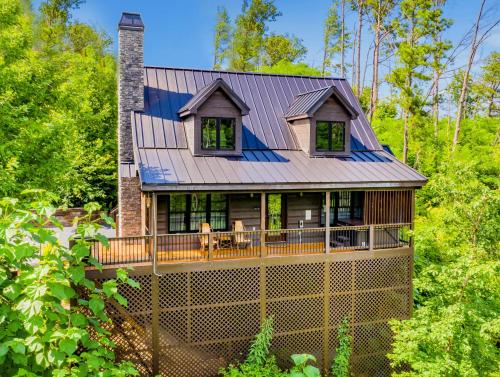 a house with a metal roof with two dogs on the deck at Black Bear Cabin by Stony Brook Cabins in Gatlinburg