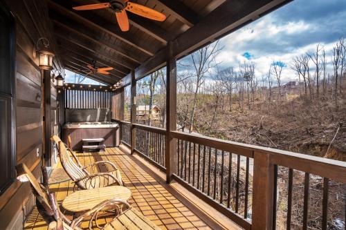 a screened in porch with a grill and chairs on it at Black Bear Cabin by Stony Brook Cabins in Gatlinburg