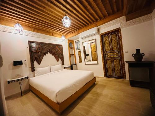 1 dormitorio con 1 cama grande y puerta grande en Riad Dar Tahri, en Fez