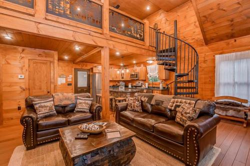a living room with leather furniture in a cabin at The Buckhorn by Stony Brook Cabins in Gatlinburg