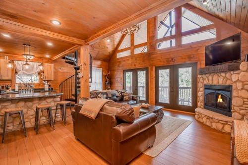 a living room with a leather couch and a fireplace at The Buckhorn by Stony Brook Cabins in Gatlinburg