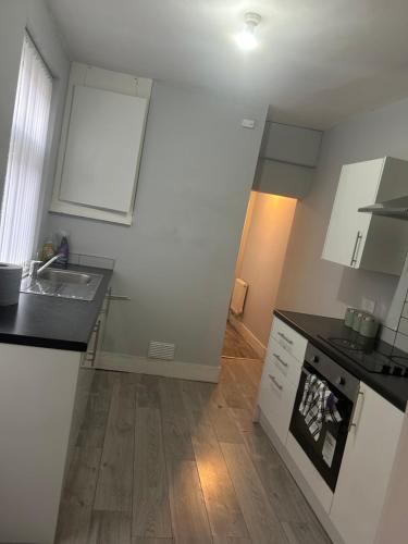 a kitchen with white cabinets and a sink at Brunswick Place XXX in Stoke on Trent