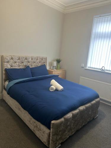 a bedroom with a blue bed with blue pillows at Brunswick Place XXX in Stoke on Trent