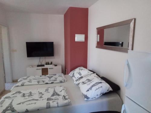 Habitación pequeña con 2 camas y TV. en Apartments Lili, en Zadar