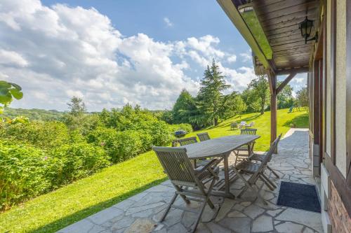 d'une terrasse avec une table et des chaises sur le côté de la maison. dans l'établissement Le Domaine des Colombages - Welkeys, à Barneville-la-Bertrand