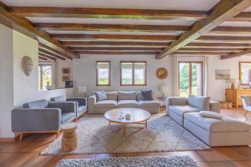 un salon avec des canapés et une table dans l'établissement Le Domaine des Colombages - Welkeys, à Barneville-la-Bertrand