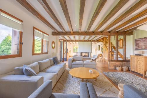 un salon avec un canapé et une table dans l'établissement Le Domaine des Colombages - Welkeys, à Barneville-la-Bertrand