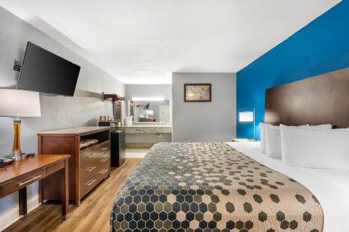 a hotel room with a large bed and a desk at Econo Lodge Inn & Suites Virginia Beach - Norfolk in Virginia Beach