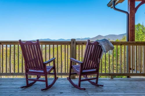 two rocking chairs sitting on a deck with mountains in the background at Villa Tavia by Stony Brook Cabins in Gatlinburg