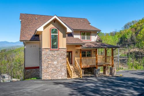 a house with a porch and a deck at Villa Tavia by Stony Brook Cabins in Gatlinburg