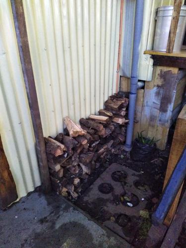 a pile of fire wood next to a building at Cabaña interior 4 personas in Quellón