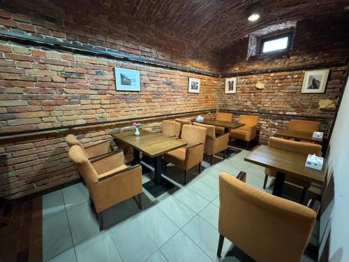 een restaurant met tafels en stoelen en een bakstenen muur bij IRIS Aparthotel in Krakau