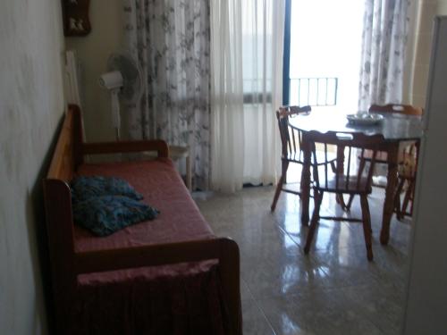 un salon avec un canapé et une table à manger dans l'établissement Attard Seafront Apartment 3 in Marsalforn, à Żebbuġ
