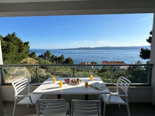 uma mesa e cadeiras numa varanda com vista para o oceano em Apartment Ante em Brela