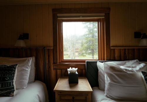a room with two beds and a window and a table at Beyul Retreat in Meredith