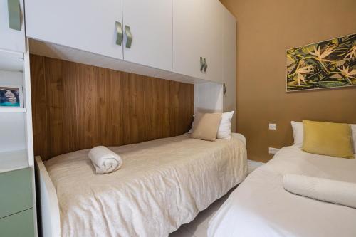 een slaapkamer met 2 bedden en witte lakens bij Happiness in Qormi