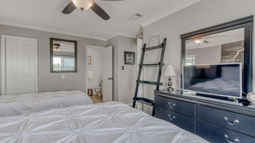 a bedroom with two beds and a dresser with a tv at Romar Village 322- short walk to beach pool in Orange Beach