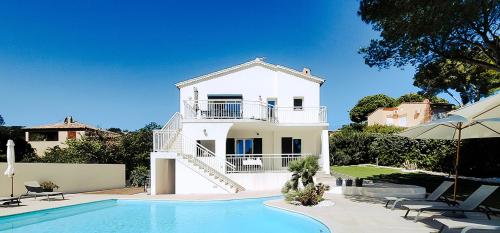 una casa blanca con piscina frente a ella en LA VILLA ALBA en Les Issambres