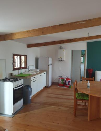 une cuisine avec une table et une cuisinière four supérieur dans l'établissement cabanon en autonomie solaire 1 a 4 personnes a 900 m des plages de valras, confort simple sans équipements energivores, à Valras-Plage
