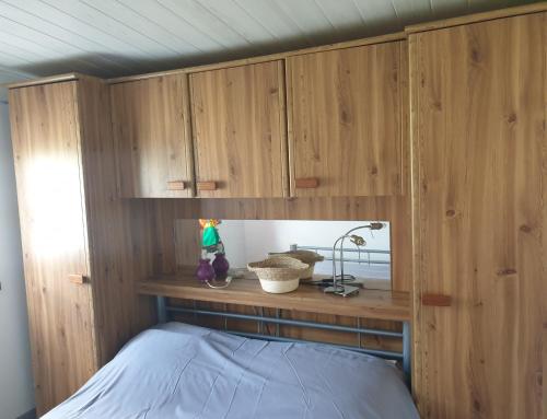 - une chambre avec des placards en bois et un lit dans l'établissement cabanon en autonomie solaire 1 a 4 personnes a 900 m des plages de valras, confort simple sans équipements energivores, à Valras-Plage