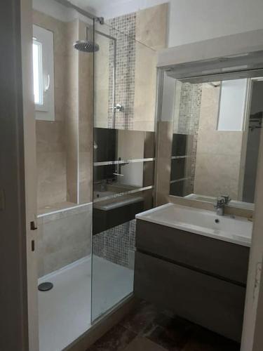 une salle de bain avec une douche, un lavabo et un miroir dans l'établissement Bas de villa avec grande piscine, à Marseille