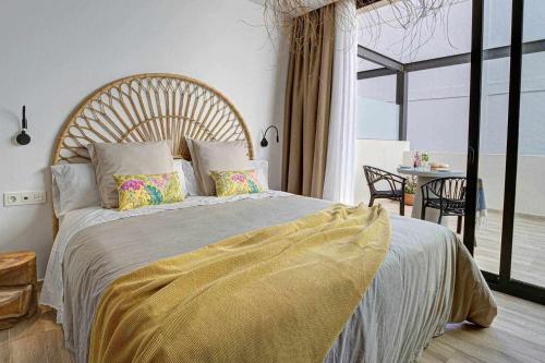 a bedroom with a large bed with a yellow blanket at Jable suites apartamentos de lujo en el centro in Corralejo