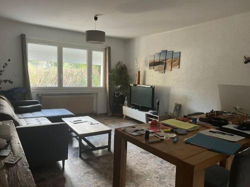 a living room with a table and a couch at Bas de villa avec grande piscine in Marseille