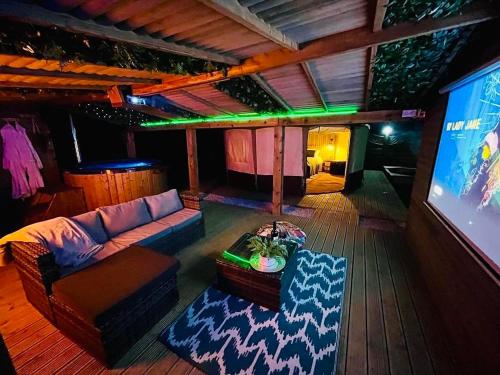 a living room with a couch and a tv at Between Rivers Camping @ The Old George Inn in Sykehouse