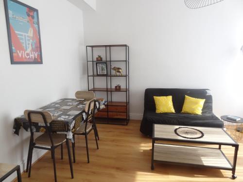un salon avec une table et un canapé dans l'établissement ''La Clé des Sources'' - Bel appartement 2 pièces - En bord d'Allier et près des thermes, à Vichy
