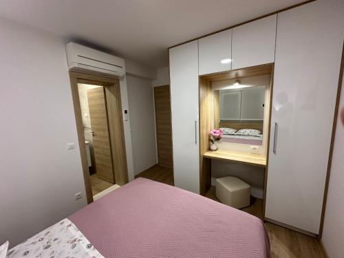 a bedroom with a pink bed and a cabinet at Apartment Ante in Brela