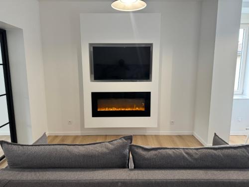 un salon avec une cheminée et une télévision dans l'établissement Appartement III - Haut Standing Proche Luxembourg & Cattenom, à Nilvange