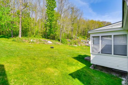 a small house in a yard next to a field at Cozy Home with ATV Trail Access in Berlin! in Gorham