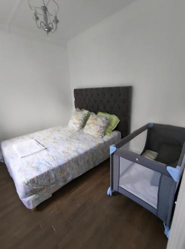 une petite chambre avec un lit et un berceau dans l'établissement Jolie Appartement indépendant, à Épinay-sur-Seine