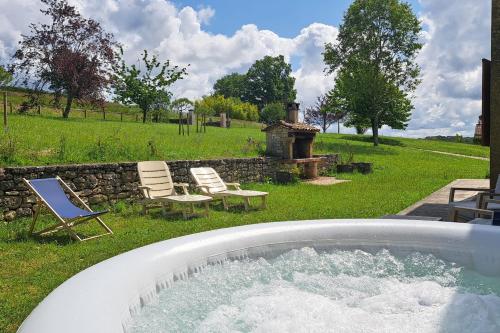 a hot tub in a yard with chairs and a grill at With the family -A peaceful stay in the countryside- spa 8-10 pers in Gaugeac