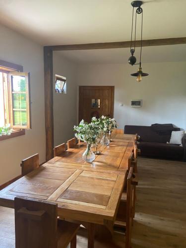 a large wooden table with flowers in vases on it at Marijini dvori in Čadjavica