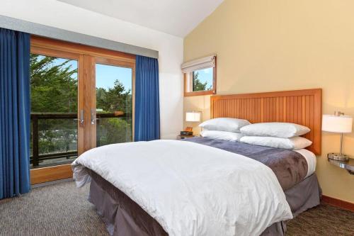 a bedroom with a large bed and a large window at Costanoa in Pescadero