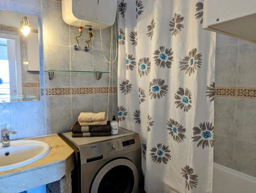 uma casa de banho com uma máquina de lavar roupa e um lavatório em Studio Playa Paraiso Tenerife - ocean view and internet wifi optical fiber - for rent em Playa Paraiso