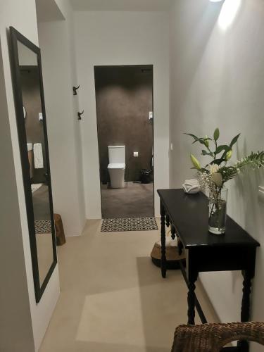 a bathroom with a black table and a toilet at Beach Room Calasol in Cala del Moral