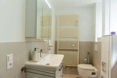 a white bathroom with a sink and a toilet at Mega Lux Apartment in Esslingen