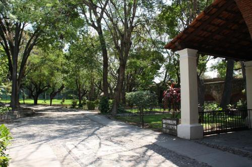 a walkway in a park with a fence and trees at Hotel Hacienda Vista Hermosa in Tequesquitengo