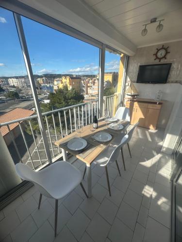 une table et des chaises sur un balcon avec vue dans l'établissement Superbe 2 pièces climatisé avec piscines, à Gruissan