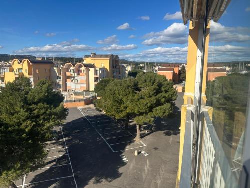 - une vue sur un parking avec des arbres et des bâtiments dans l'établissement Superbe 2 pièces climatisé avec piscines, à Gruissan