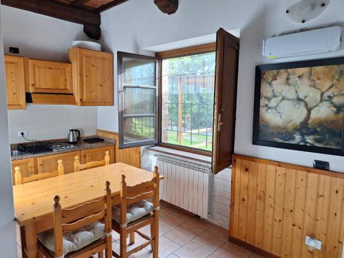 a kitchen with a wooden table and a large window at LaCollinaTuscany between San Gimignano and Volterra in Volterra