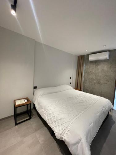 a bedroom with a white bed and a side table at Casa Valentina Habitación 3 in Aguascalientes