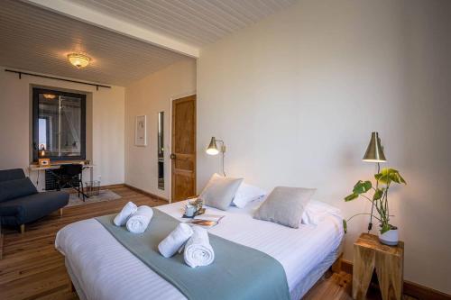 une chambre avec un grand lit avec des draps et des oreillers blancs dans l'établissement hjem petite, Port Blanc Facing the sea, à Penvénan