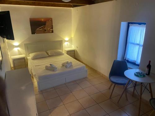 a bedroom with a bed and a table and a chair at Kalamitsi House 2 in Agia Pelagia
